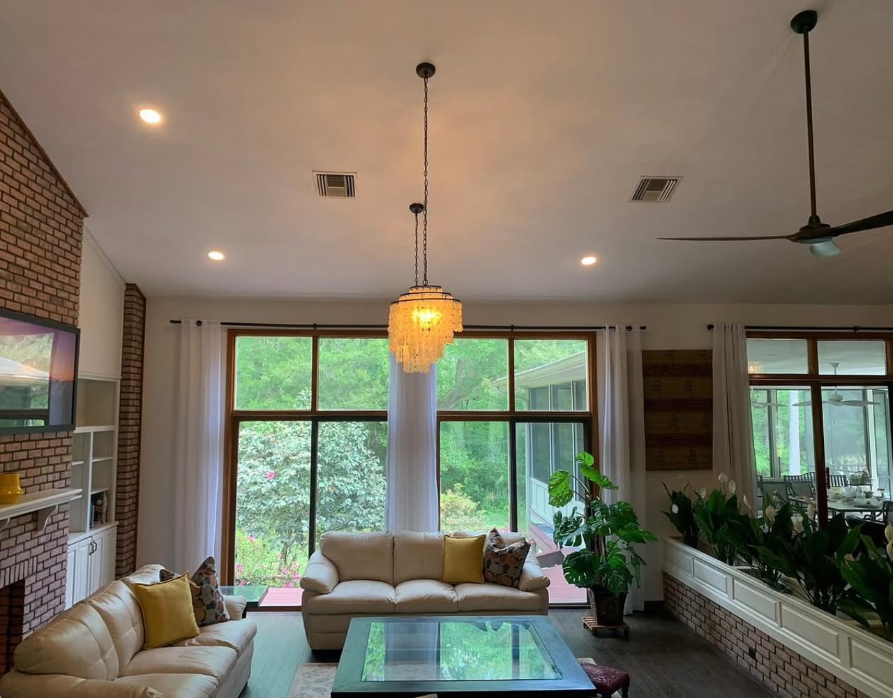 Bright living room with brick fireplace and chandelier