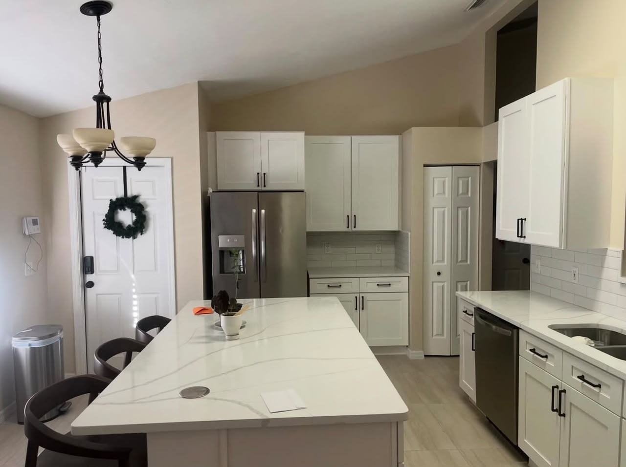 White shaker kitchen with quartz waterfall island